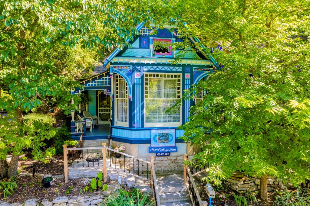 a blue house in the middle of some trees at Cliff Cottage Inn, Downtown Bed & Breakfast in Eureka Springs