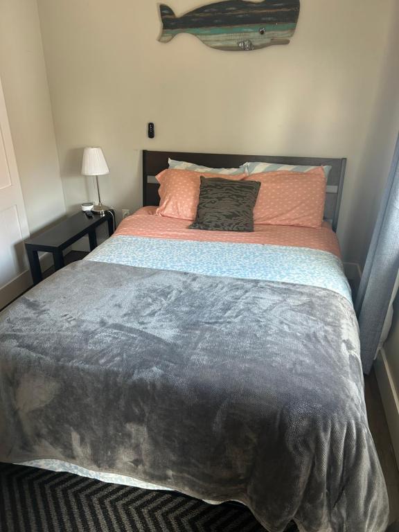 a bedroom with a large bed with a gray blanket at Dougs house in Niagara Falls