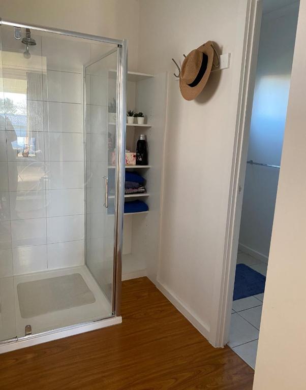 a shower with a glass door in a bathroom at Coronet Bay Beach Cabin in Coronet Bay