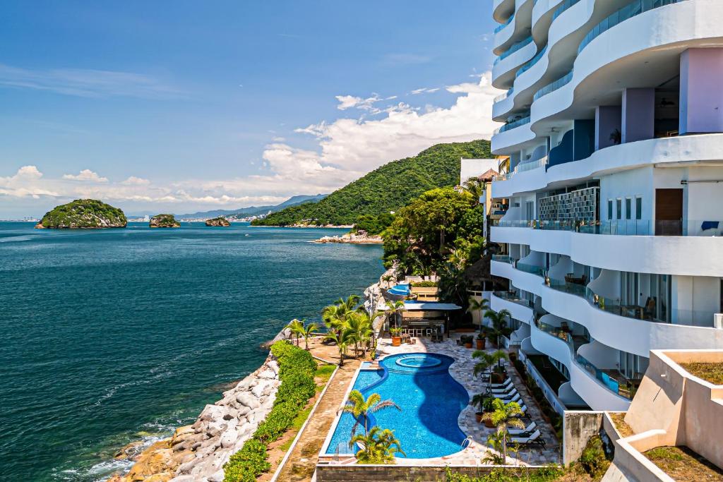 a view of the ocean from the balcony of a hotel at Modern condo with ocean views, rooftop infinity pool & central AC in Puerto Vallarta