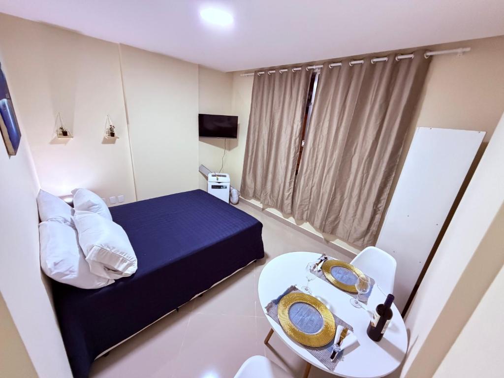a small room with a bed and a table at Studio 302 Centro Imperial in Petrópolis