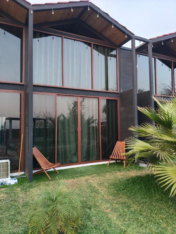 a house with two benches in front of it at Cabañas La Cascada in Tepoztlán