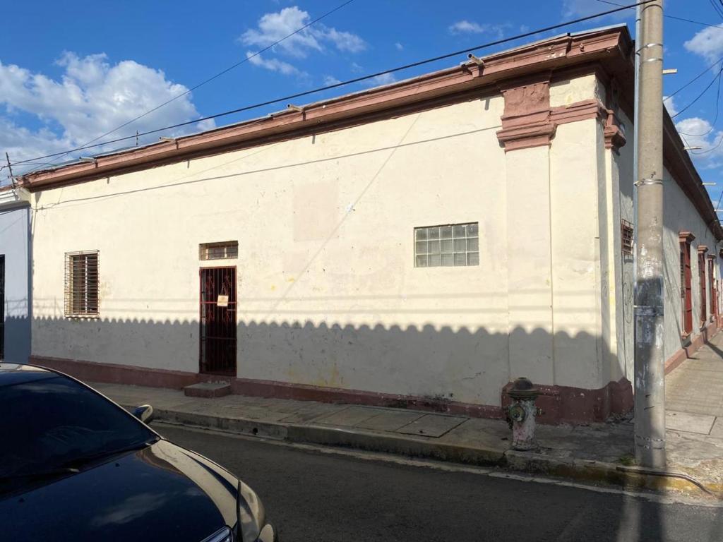 a white building on the side of a street at Hostal Casa Colonial in Santa Ana