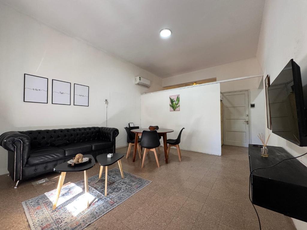 a living room with a black couch and a table at Apto Mitre in San Juan
