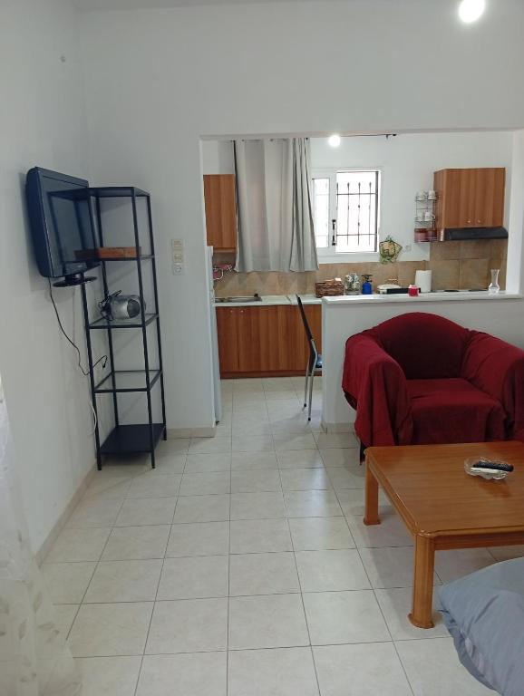 a living room with a red couch and a kitchen at Summer House 96 in Salamina