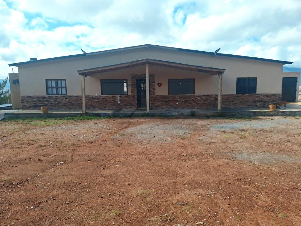 a large white building with a dirt field in front of it at Cabaña Marmolejo in Arteaga