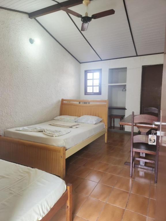 a room with two beds and a ceiling fan at Solemar in Guarapari