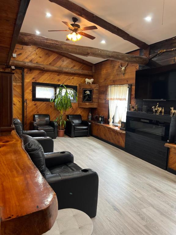 a living room with leather furniture and a flat screen tv at Beautiful cabin surrounded by nature in Catskill