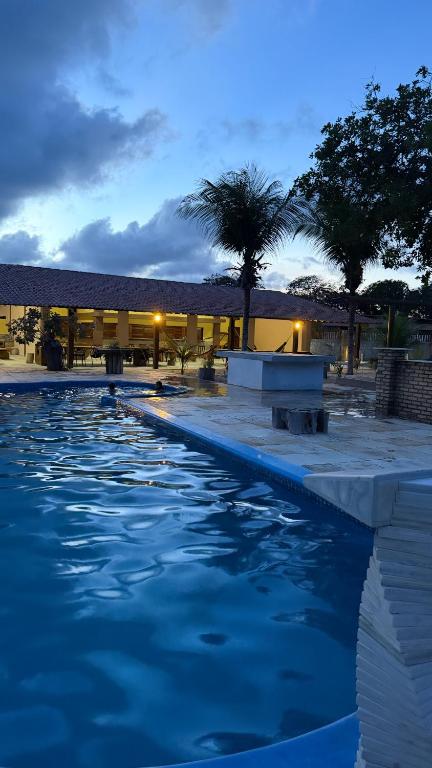 a swimming pool with blue water in front of a building at Hotel Fazenda Alta Vista in Fortim