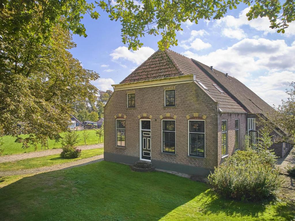 an old brick house with a grass yard at t Voorhuis Kolderveen in Nijeveen