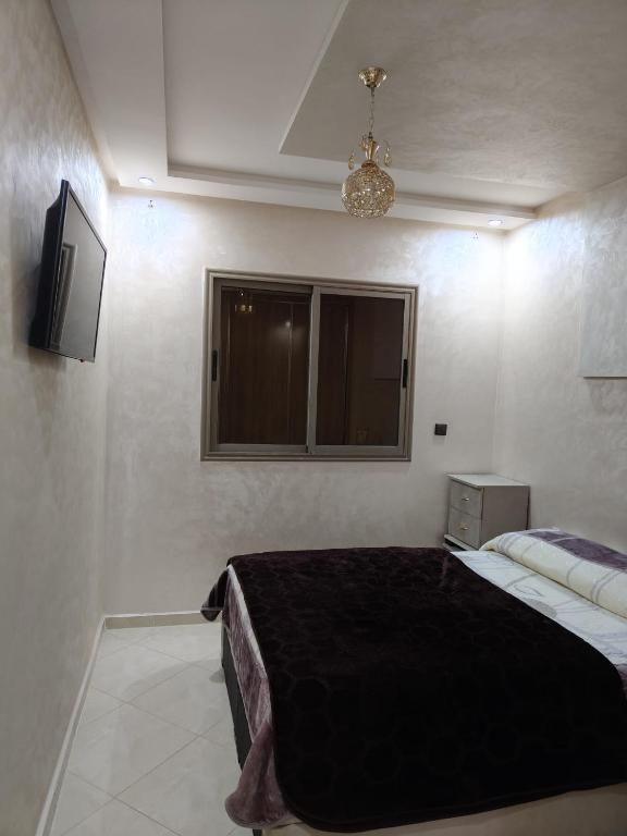 a bedroom with a bed with a black blanket at Khouribga in Khouribga