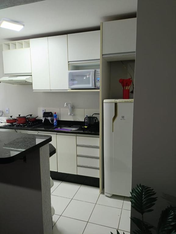 a kitchen with white cabinets and a white refrigerator at Apto Térreo Próximo HU e Aeroporto Vaga e Ar in Londrina