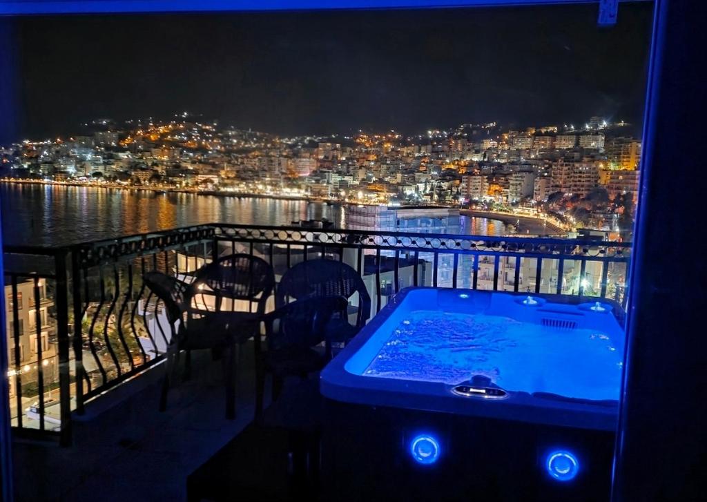 a hot tub on top of a balcony at night at Duplex Penthouse with Jacuzzi in Sarandë