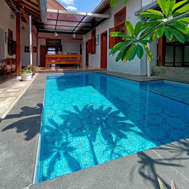 a swimming pool with a blue flooring in a house at Sabi House Kates in Timuran