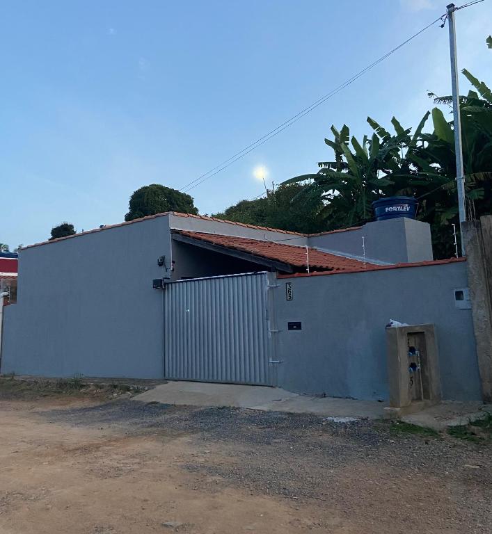 a white building with a gate and a fence at Casa disponível para temporada in São Roque de Minas