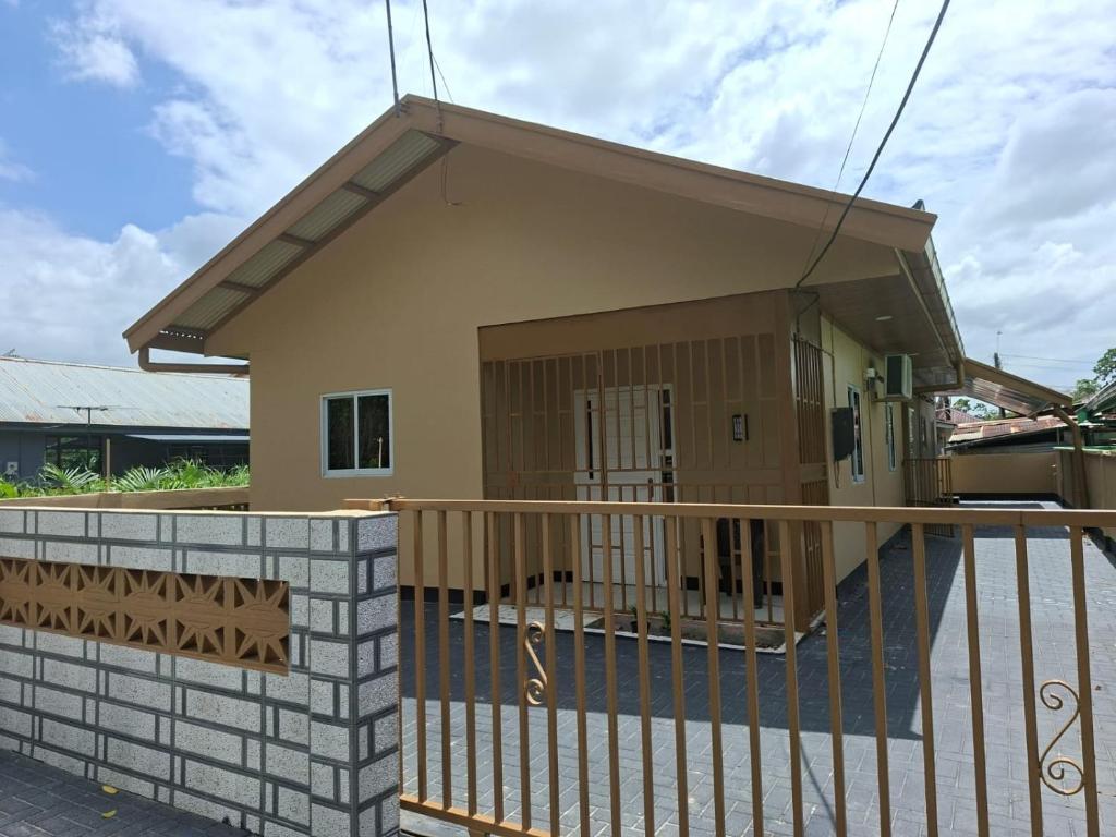 a house with a gate and a balcony at Zara Appartement in Paramaribo