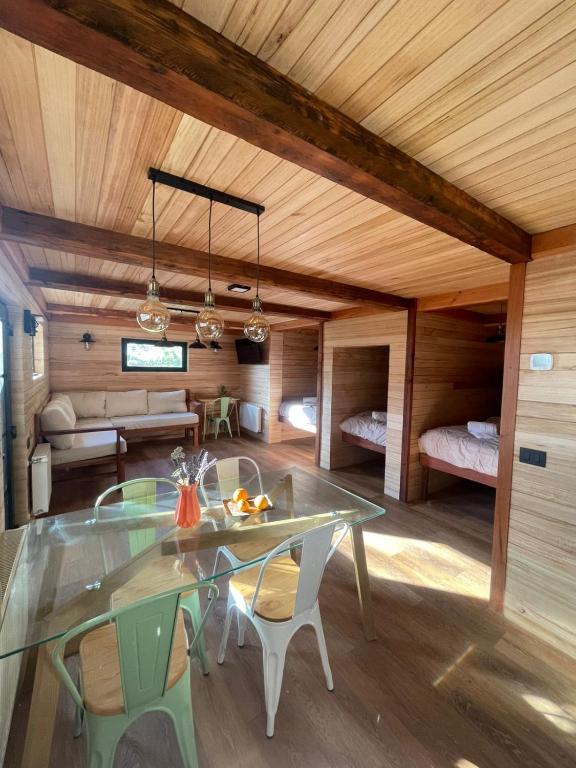a dining room with a glass table and chairs at Tiny Under Chalet in Santiago