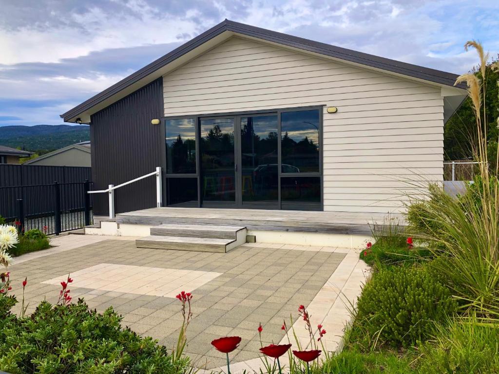 a house with glass doors and a patio at Modern Spacious Manapouri Home in Manapouri