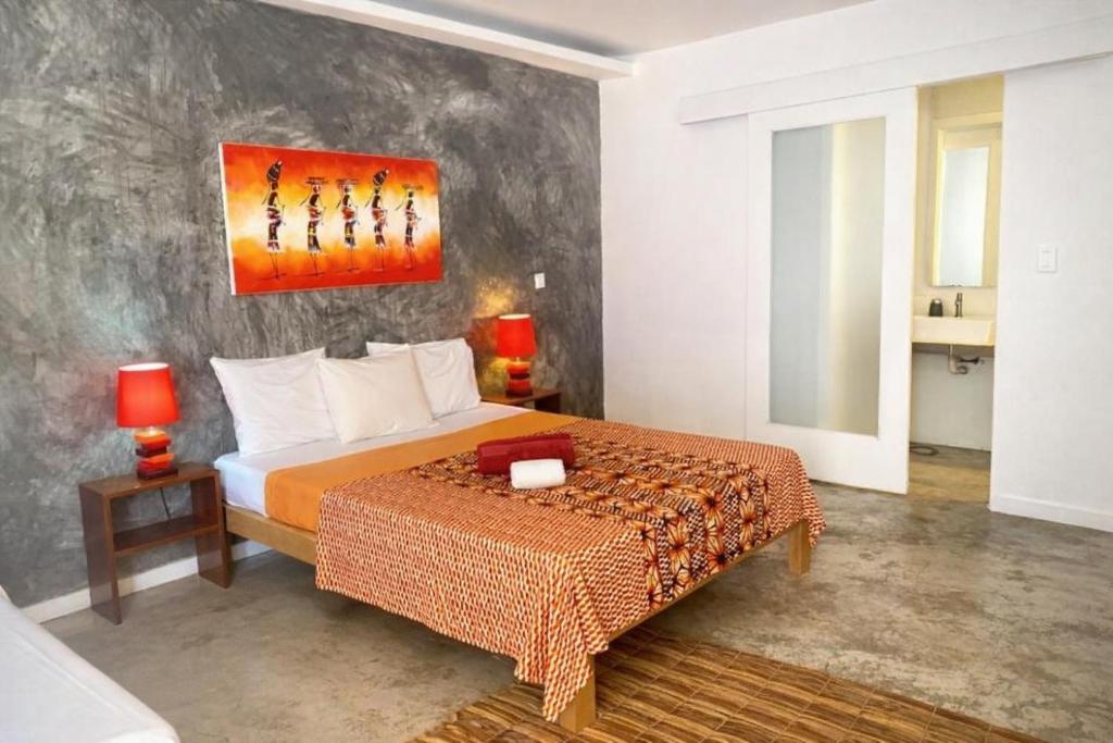 a bedroom with a bed and a painting on the wall at Hotel PZero in São Tomé
