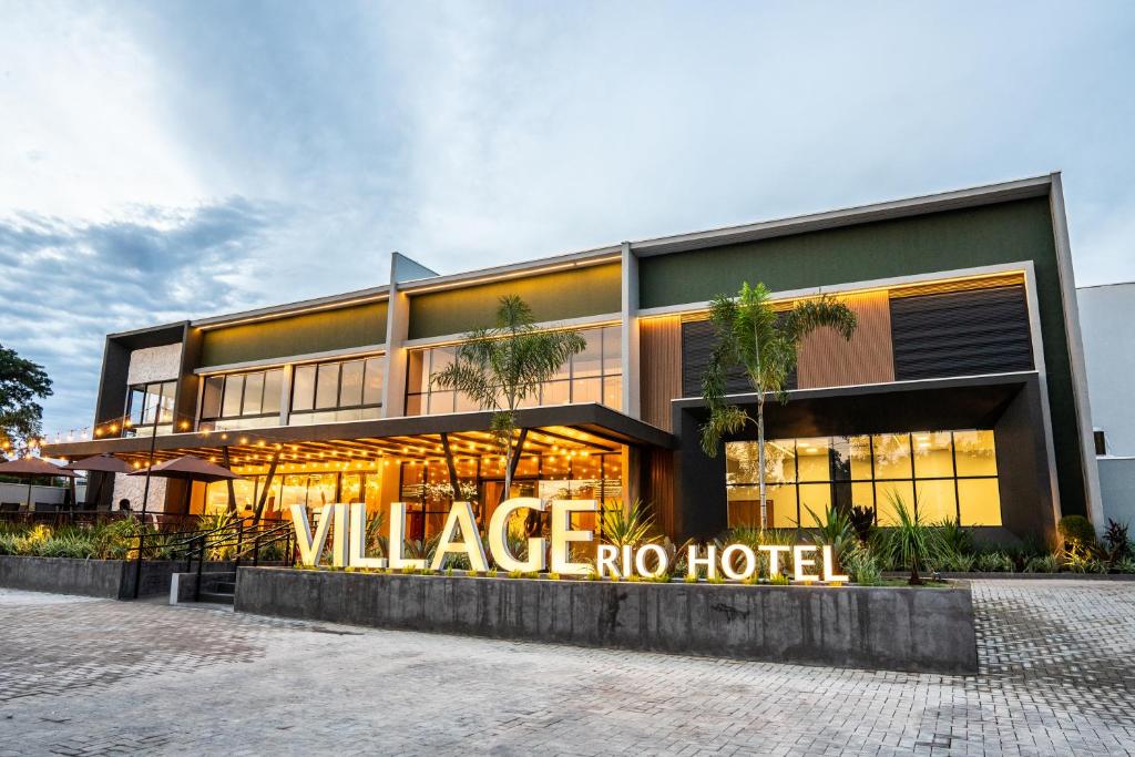 a large building with a sign that reads village no hotel at Village Rio Hotel in Chavantina