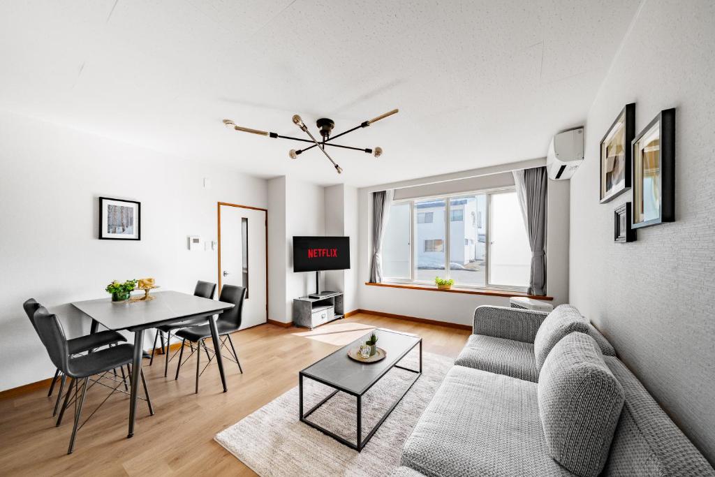 a living room with a couch and a table at Asahikawa Stay Ecole 101 in Asahikawa