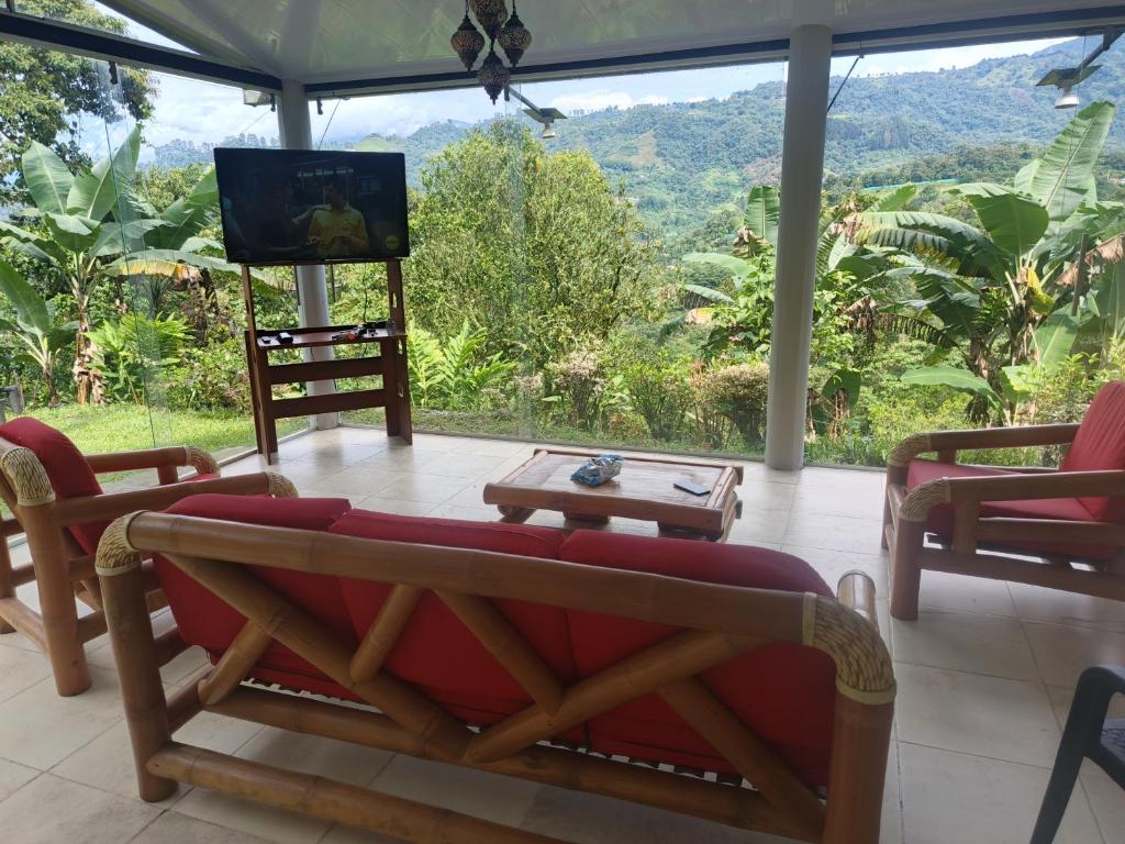 a living room with a tv and a couch and a table at Refugio en la naturaleza in La Vega