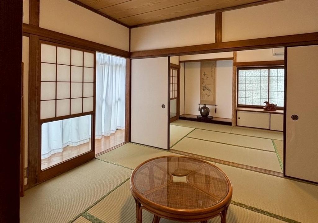 a room with a table and some windows at 一棟貸の宿さくらんぼ in Kami-yuge