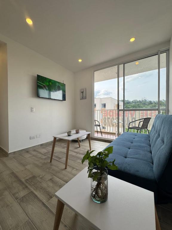 a living room with a blue couch and a table at Oasis Villeta Apartamento in Villeta