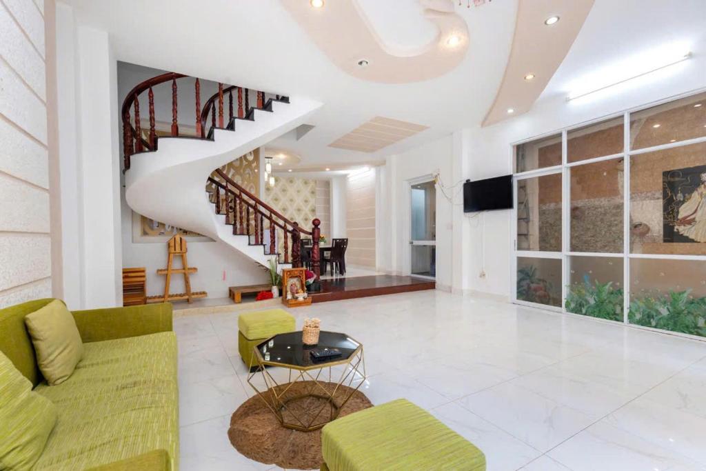 a living room with a couch and a staircase at Homestay 30 Võ Thị Sáu in Vung Tau