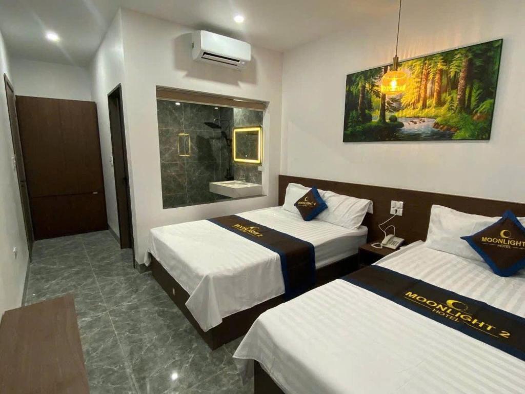a hotel room with two beds and a bathroom at Moonknight 2Hotel in Sầm Sơn