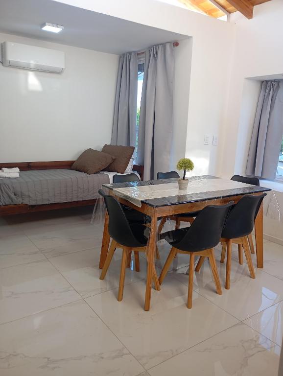 a dining room table and chairs in a living room at YulFran in Mina Clavero