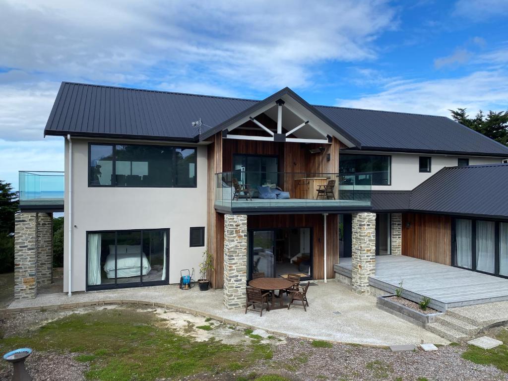 a house with a black roof at Secluded coastal comfort in Dunedin