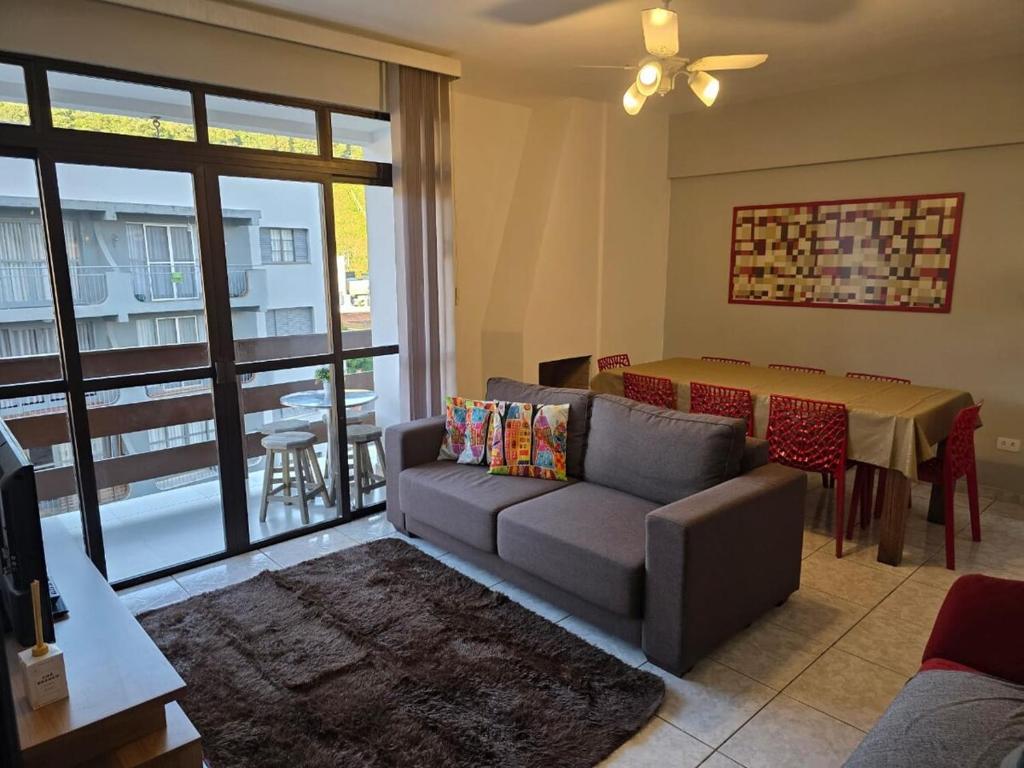 a living room with a couch and a table at Apto a 3 quadras do centro, 2 quartos lazer comp in Serra Negra