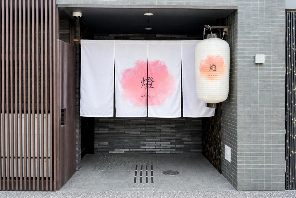 京都市にあるホテル燈-akari-の建物から吊り下げられた白と赤の旗