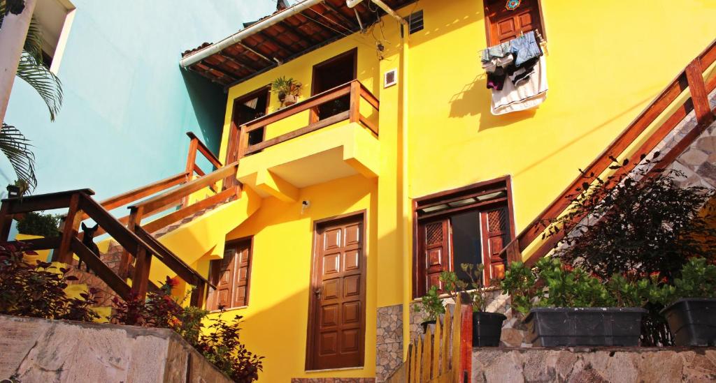Casa amarilla con puertas y ventanas de madera en Casa da Val, en Morro de São Paulo