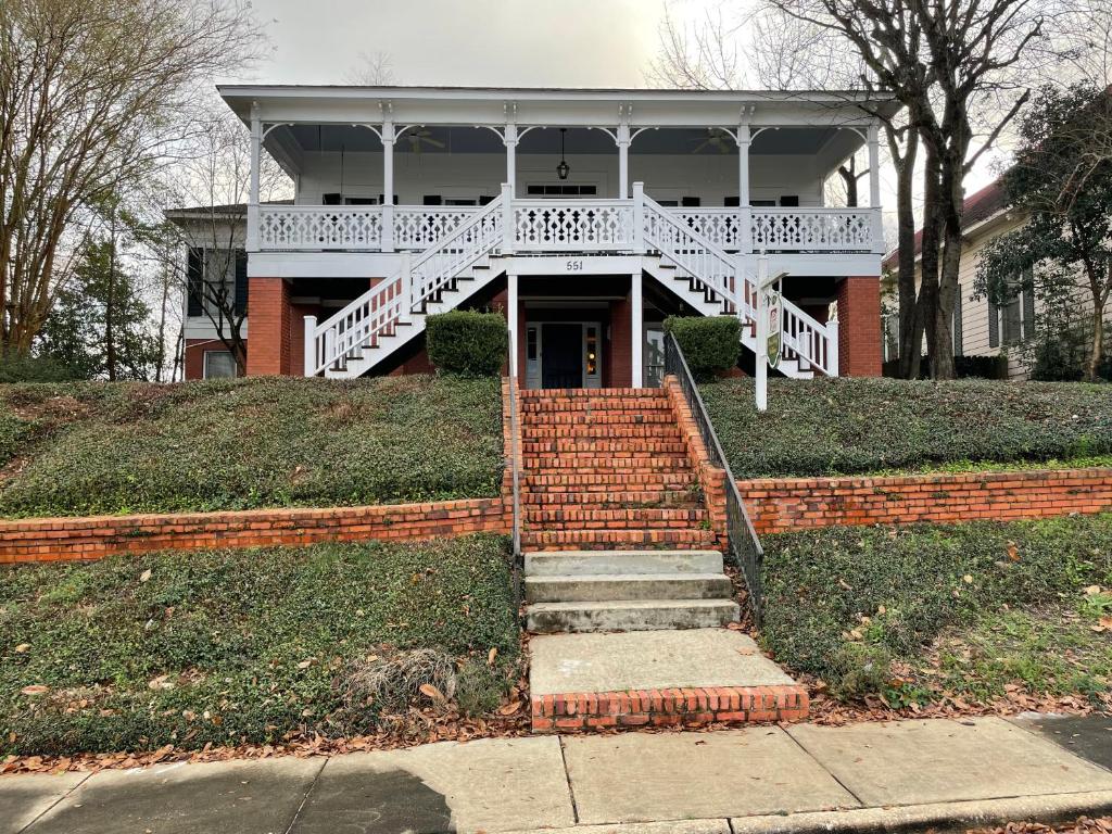 a house with a white porch and stairs in front at Red Bluff Cottage in Montgomery