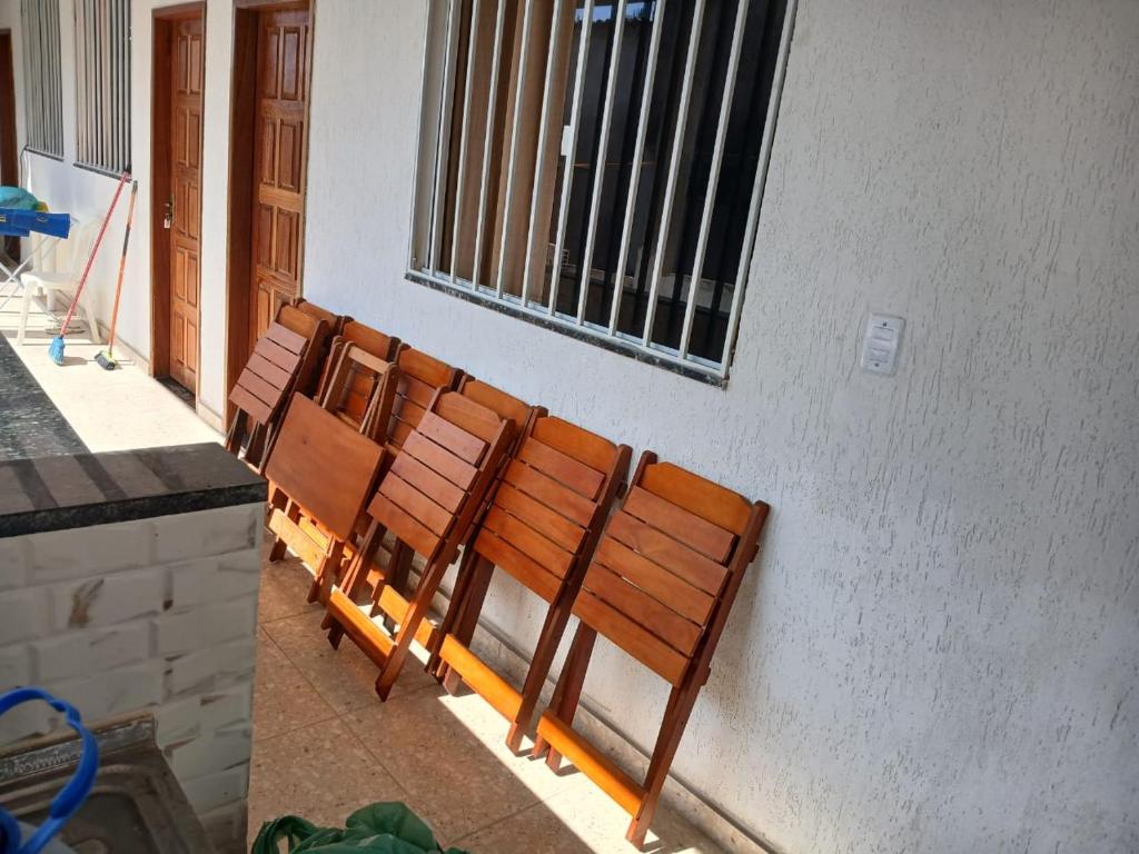 a row of wooden benches sitting next to a building at Pousada Coutinho in Paraty