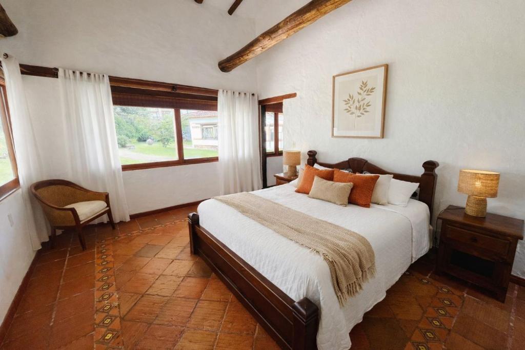 a bedroom with a large bed and a window at Hacienda Campestre Oasis de la Villa in Villa de Leyva