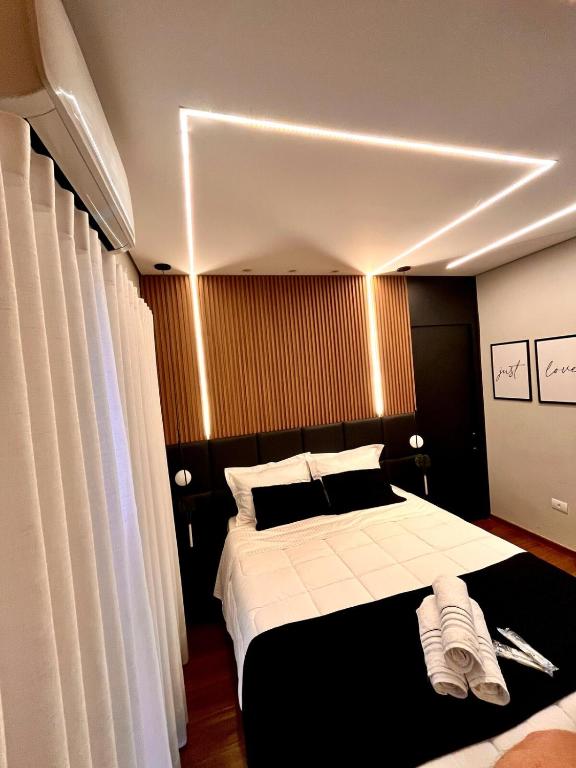 a bedroom with a large bed with black and white at Super comfortable house 3 bedrooms in Paranavaí