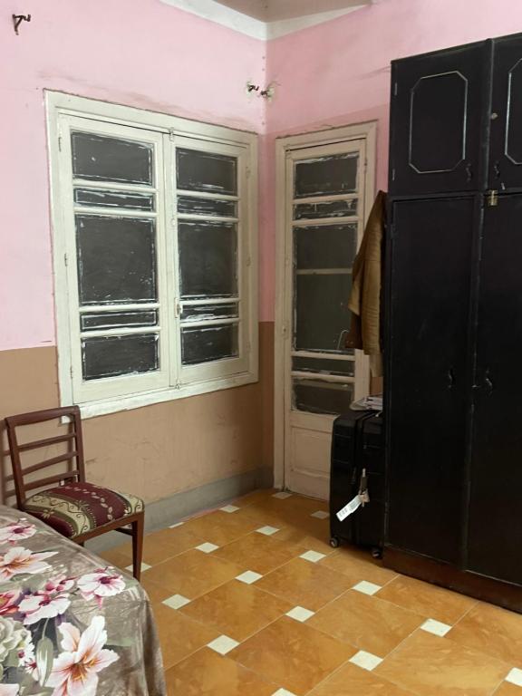 a bedroom with pink walls and two windows and a chair at Beit Gedi in Cairo