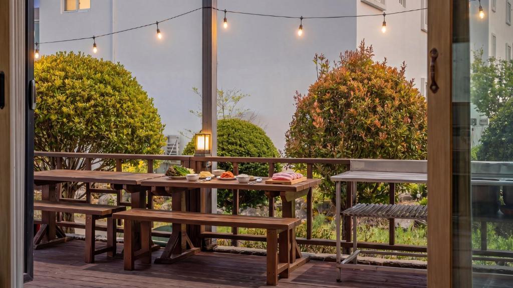 a table and benches on a balcony with a view at suncheon romance pension in Suncheon