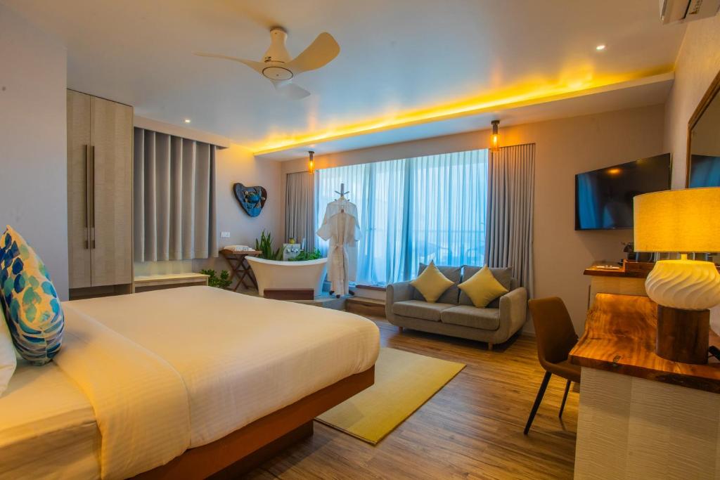 a bedroom with a bed and a living room at Coconut Tree Hulhuvilla Beach in Hulhumale