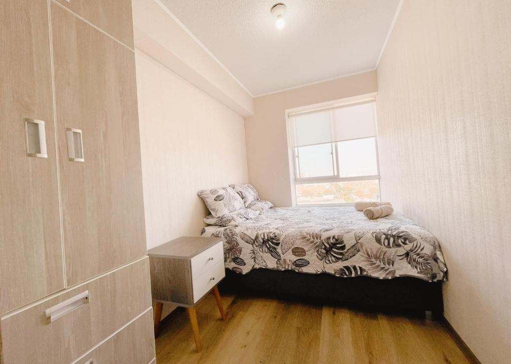 a small bedroom with a bed and a window at Apacible y acogedora habitación con vista a Barranco in Lima