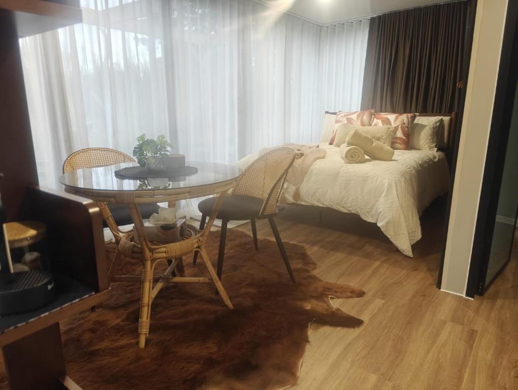 a bedroom with a table and a bed and a table and chairs at Huruhuru Hideaway! Private Cabin in Otatara