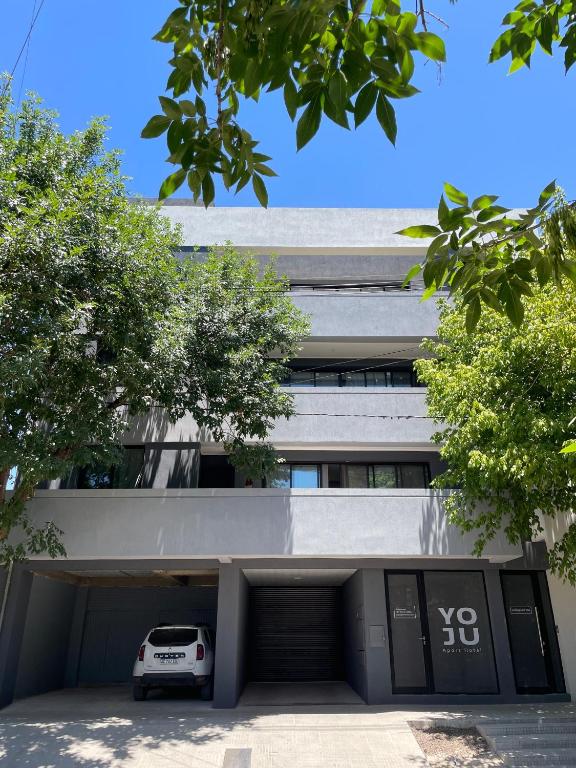 a car parked in a parking lot in front of a building at YOJU aparthotel in Colón