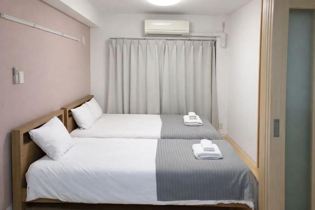a bedroom with two beds with towels on them at 桜の恋 in Osaka