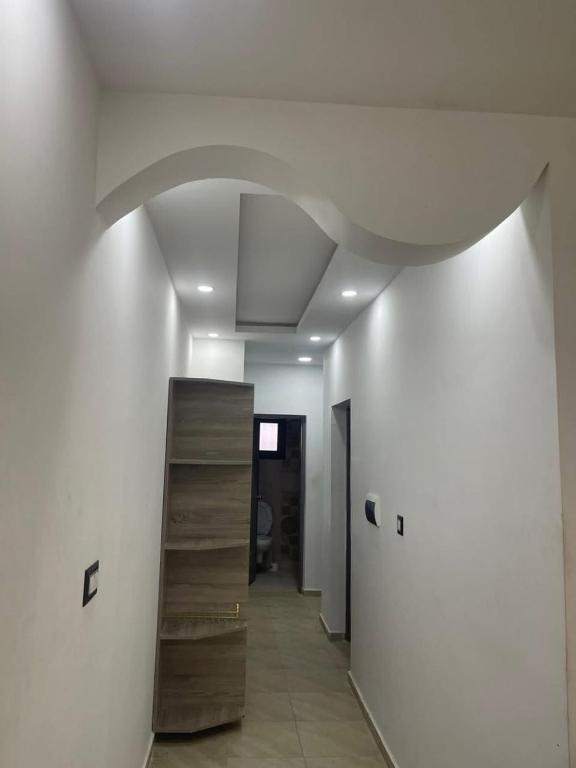 a hallway with a white ceiling and a staircase at Chez montasser in Al Maqārisah