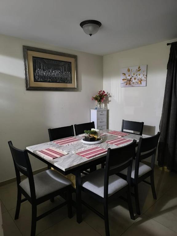 a dining room table with chairs and a plate of food on it at Los Senderos in San Juan Opico