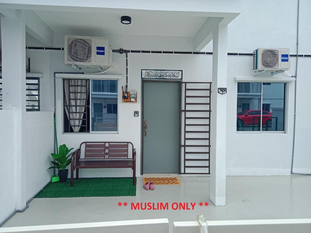 a front porch of a house with a door and a bench at D'Suriah Homestay in Tanjung Karang