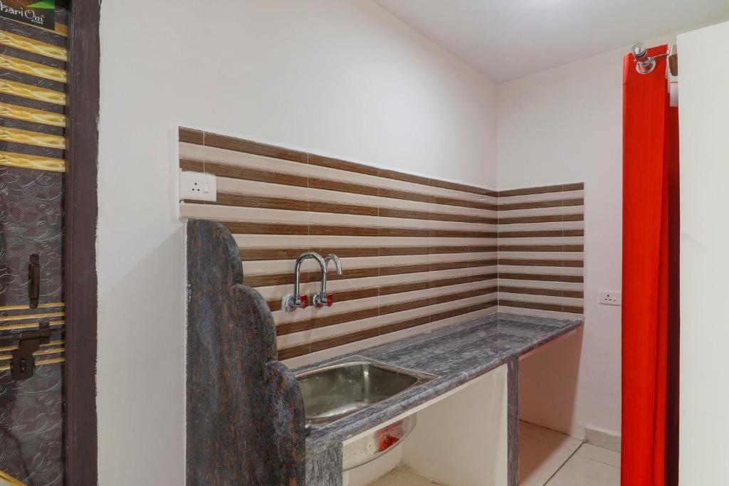 a kitchen with a sink in a room at Hotel O Home RBS Homes in Hyderabad